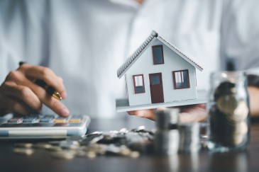 Immobilienrente - Mensch mit Haus und Taschenrechner