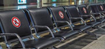 Sitzbänke am Flughafen mit Abstandsmarkierungen 