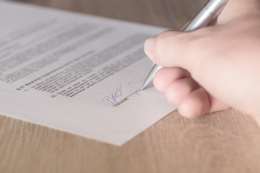 Person unterschreibt Dokument