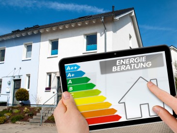 Energieberatungmit Tablet vor Haus