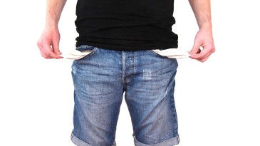 Symbolfoto Schulden: Mann mit leeren Hosentaschen
