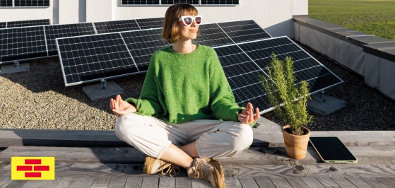 Frau genießt Sonne mit Photovoltaik-Quelle Bausparkasse Schwäbisch Hall,