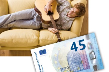 Junger Mann mit Gitarre auf dem Sofa und Geldschein 45 Euro